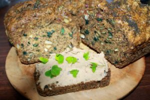Seed bread with dried mallow added. A slice with bean humus and oxalis garnish